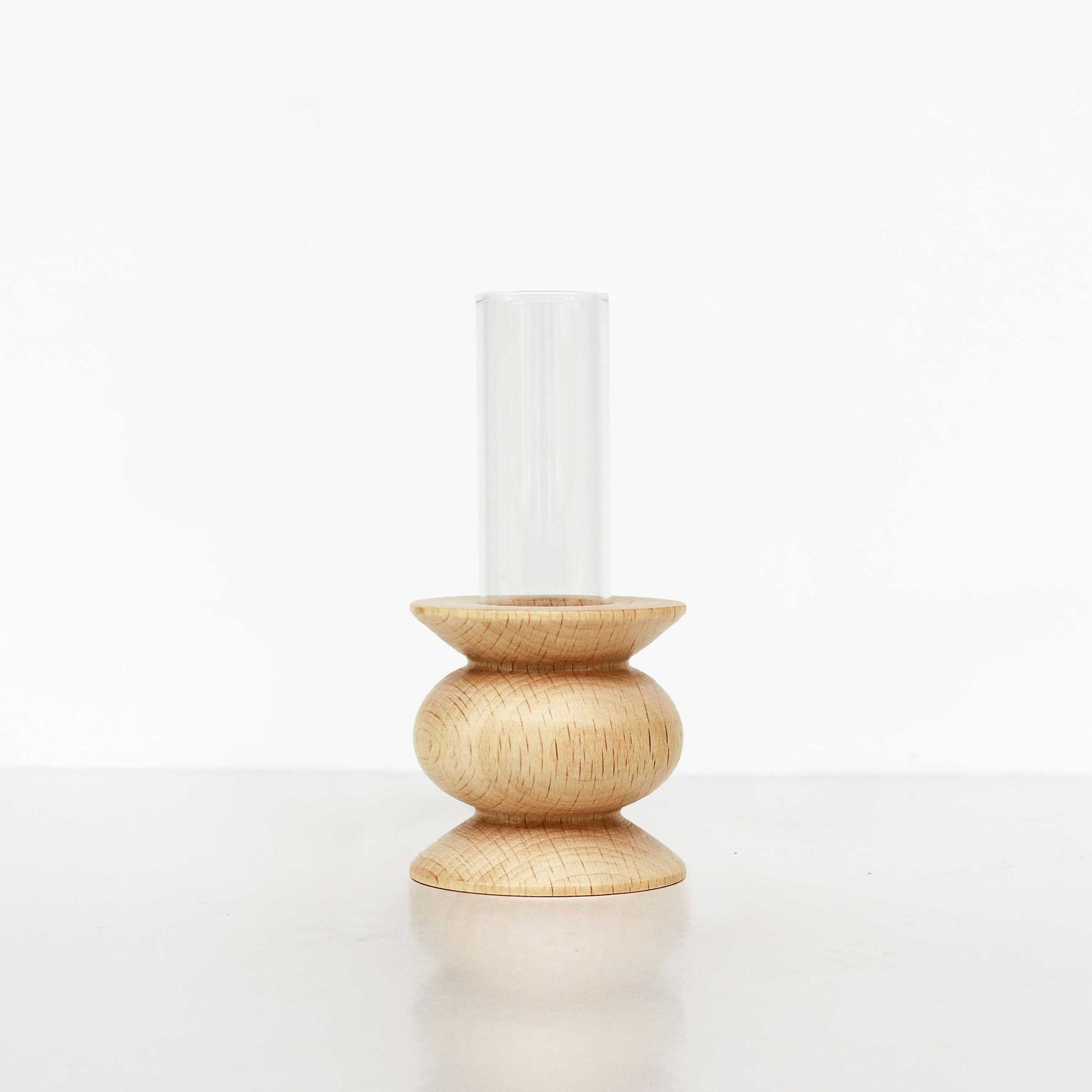 playful short totem wooden vase with a single bright flower in a sunlit room