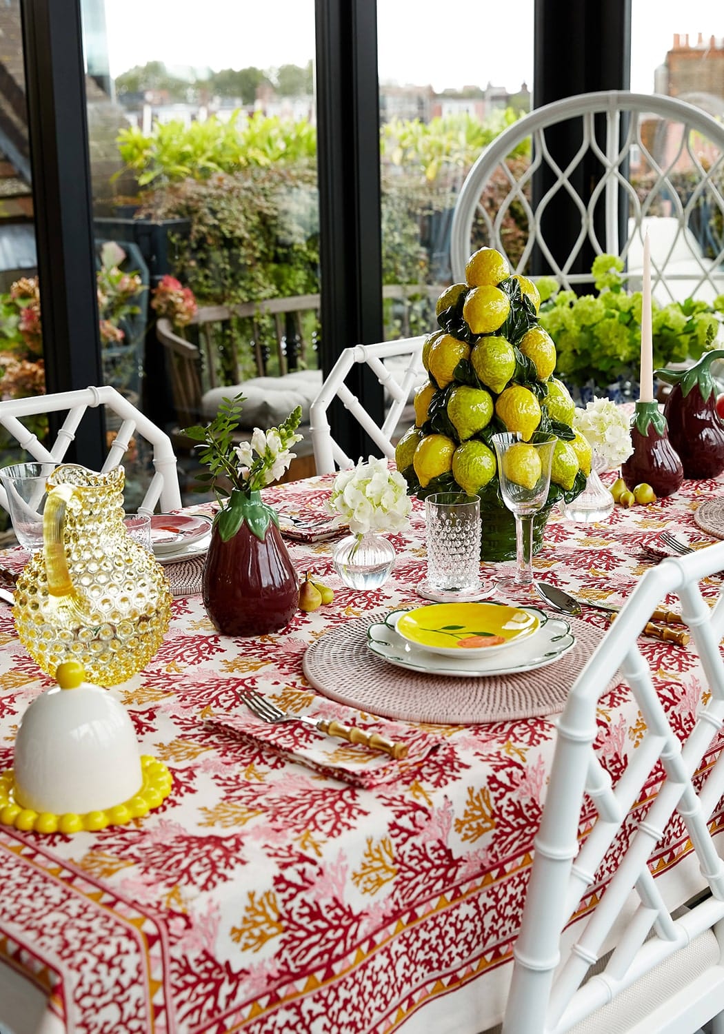 patterned tablecloth with lemon themes pottery on the table top in a summery garen on Sostter