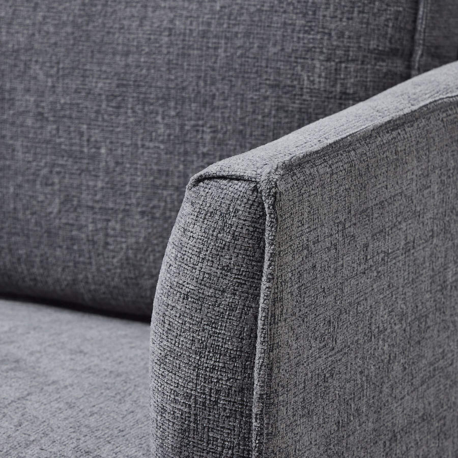Grey fabric armchair with curved arms, modern design, and plush upholstery for stylish living room seating by Sostter at brixbailey.com