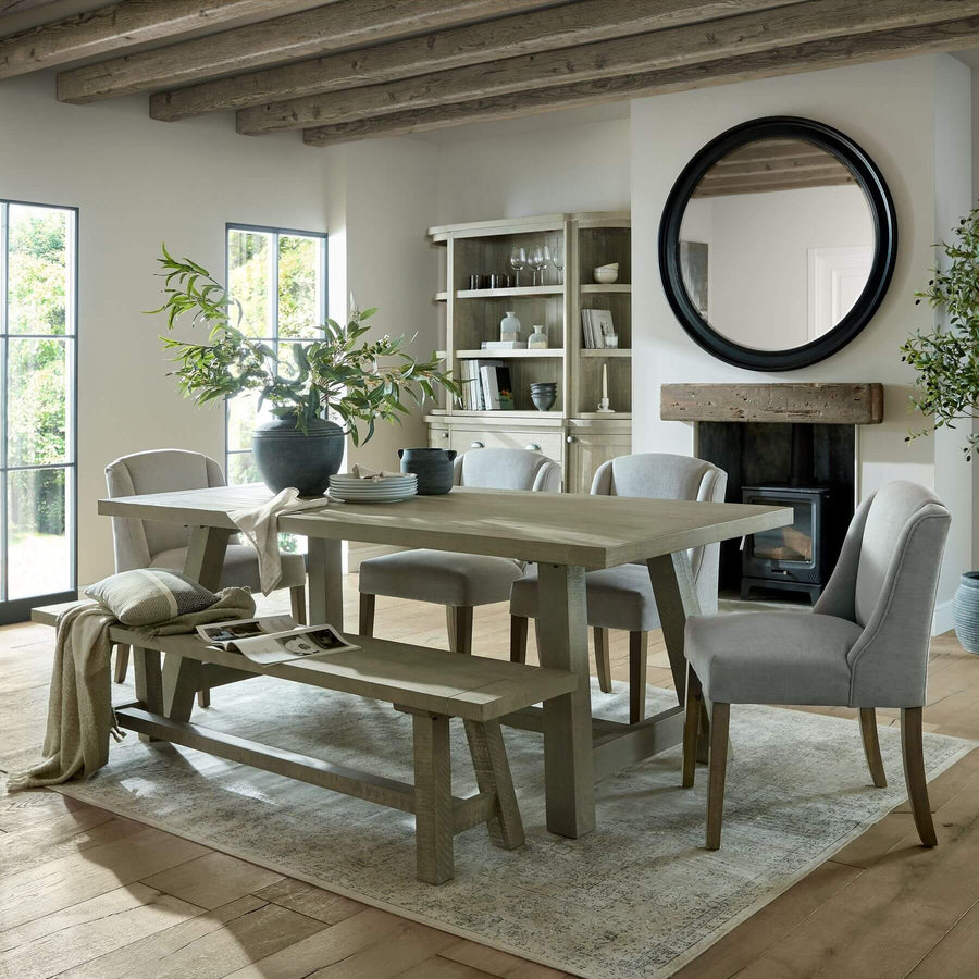 Handcrafted curved pine dining bench in grey-wash finish, seating 3, with rustic-modern design for farmhouse or Scandinavian interiors. by Hill Interiors at brixbailey.com