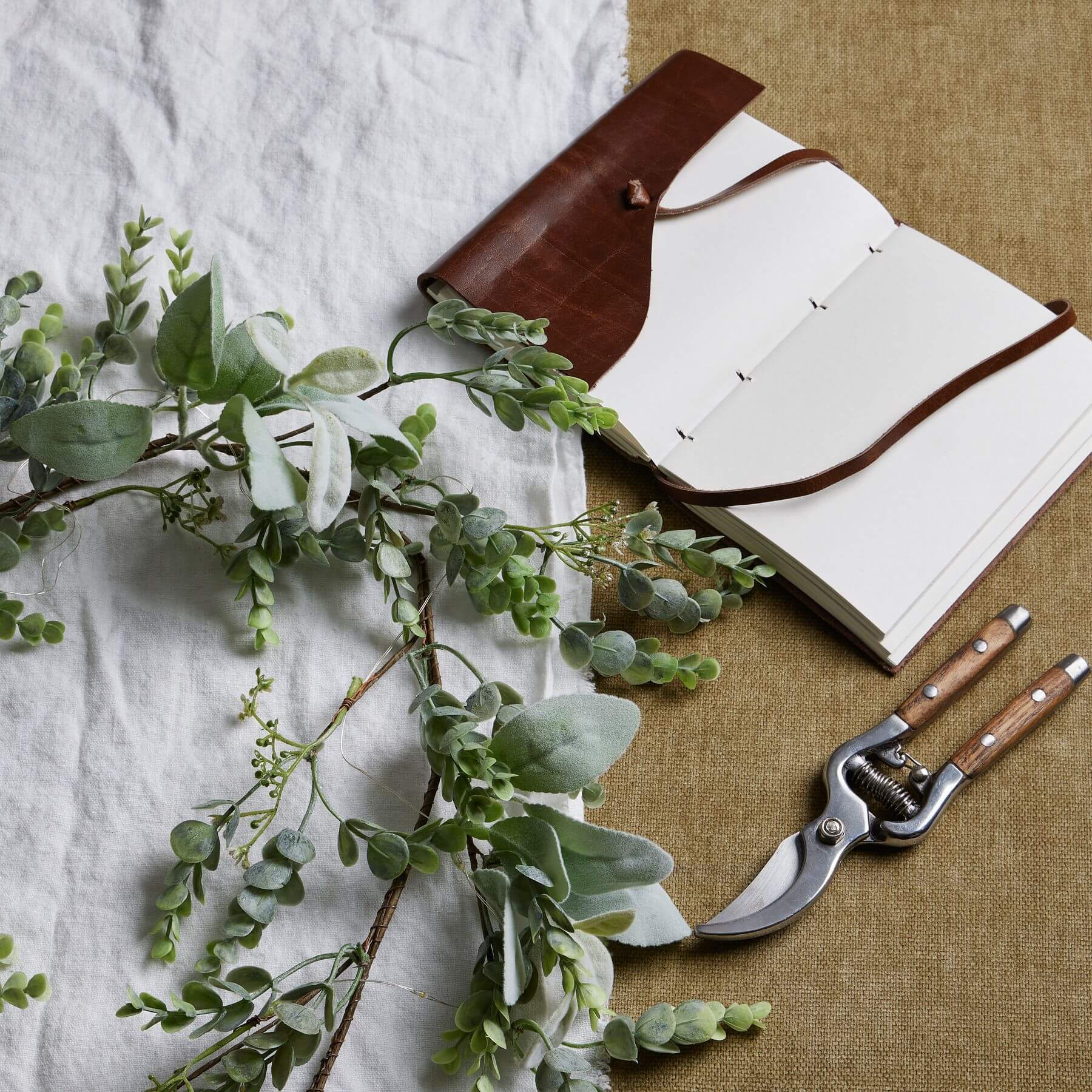 Frosted eucalyptus LED garland with silver accents, 5 feet long, battery-operated winter decor for mantels or staircases by Sostter at brixbailey.com
