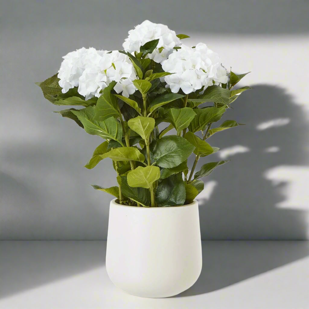 Lifelike white hydrangea arrangement with green foliage, realistic plastic petals, perfect for farmhouse or modern decor by Sostter at brixbailey.com