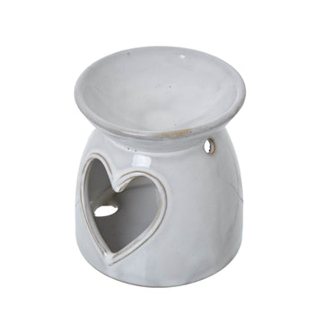 White ceramic tealight holder with heart cut-outs, casting delicate light patterns for cozy ambiance by Sostter at brixbailey.com