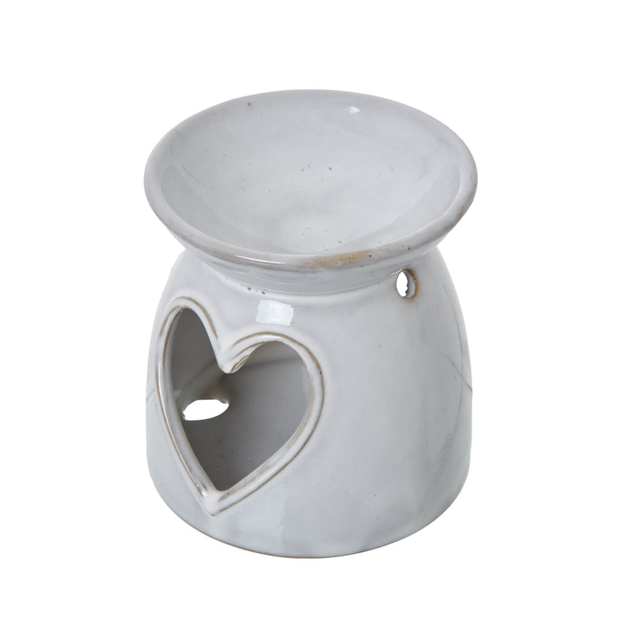White ceramic tealight holder with heart cut-outs, casting delicate light patterns for cozy ambiance by Sostter at brixbailey.com