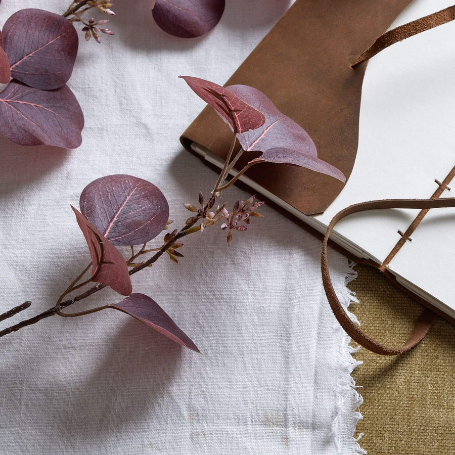 Burgundy berried eucalyptus stem with lifelike plastic leaves and berries, perfect for seasonal home decor by Sostter at brixbailey.com
