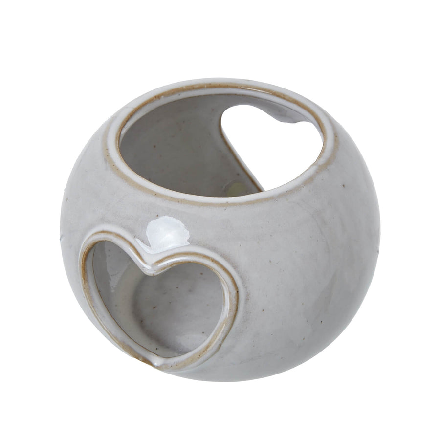 White ceramic tealight holder with heart-shaped cutouts, creating warm ambient light patterns by Hill Interiors at brixbailey.com