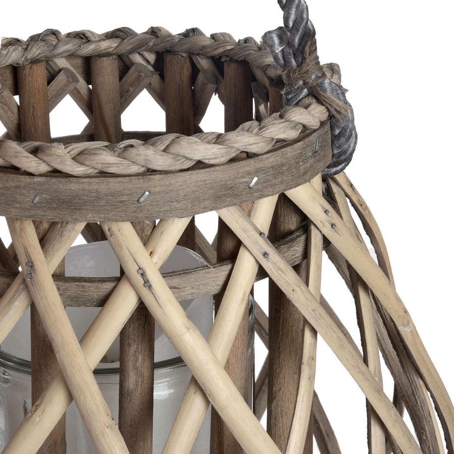 Handwoven rattan lantern with bulbous shape, natural brown wicker, casting warm light patterns for home decor. by Sostter at brixbailey.com