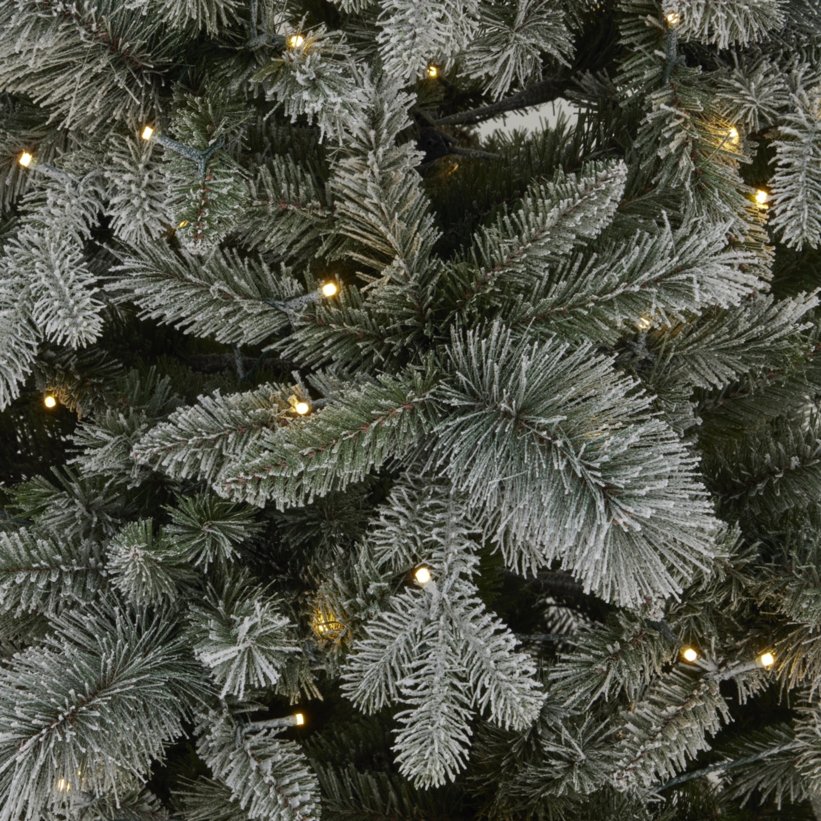 a softly glowing snowy fir tree with warm lights, creating a cozy cottage retreat atmosphere