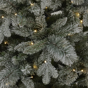 a softly glowing snowy fir tree with warm lights, creating a cozy cottage retreat atmosphere