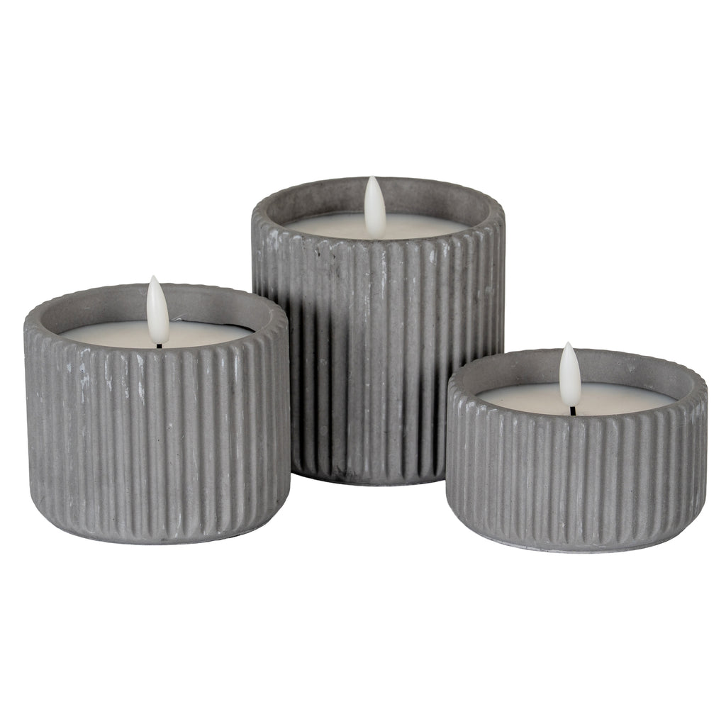 a playful grey ribbed led candle casting fun, dancing shadows in warm evening light