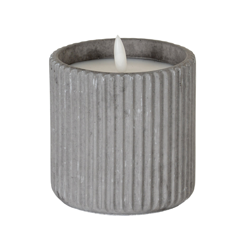 bold grey ribbed led candle casting dramatic shadows with its warm natural glow