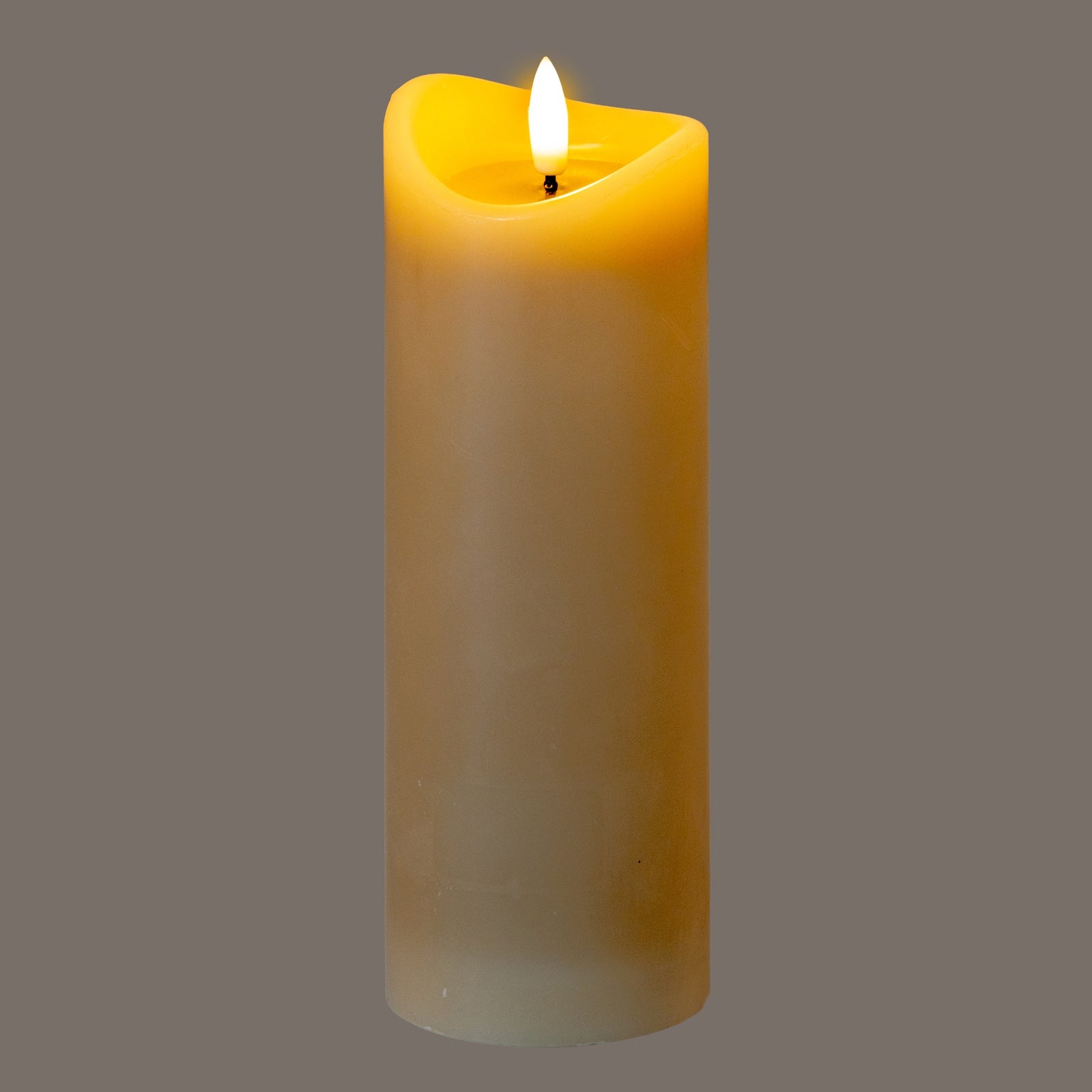 a softly glowing taupe led candle with a melted wax top, casting a warm, comforting light in a minimalist room