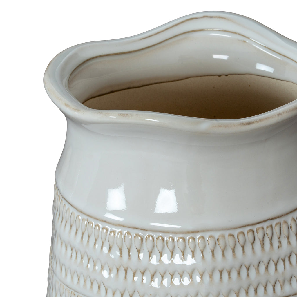 a soft white ceramic vase with a gently textured hewn surface, glowing in warm morning light