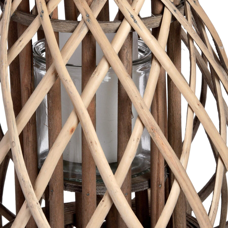 Handwoven rattan lantern with bulbous shape, natural brown wicker, casting warm light patterns for home decor. by Sostter at brixbailey.com