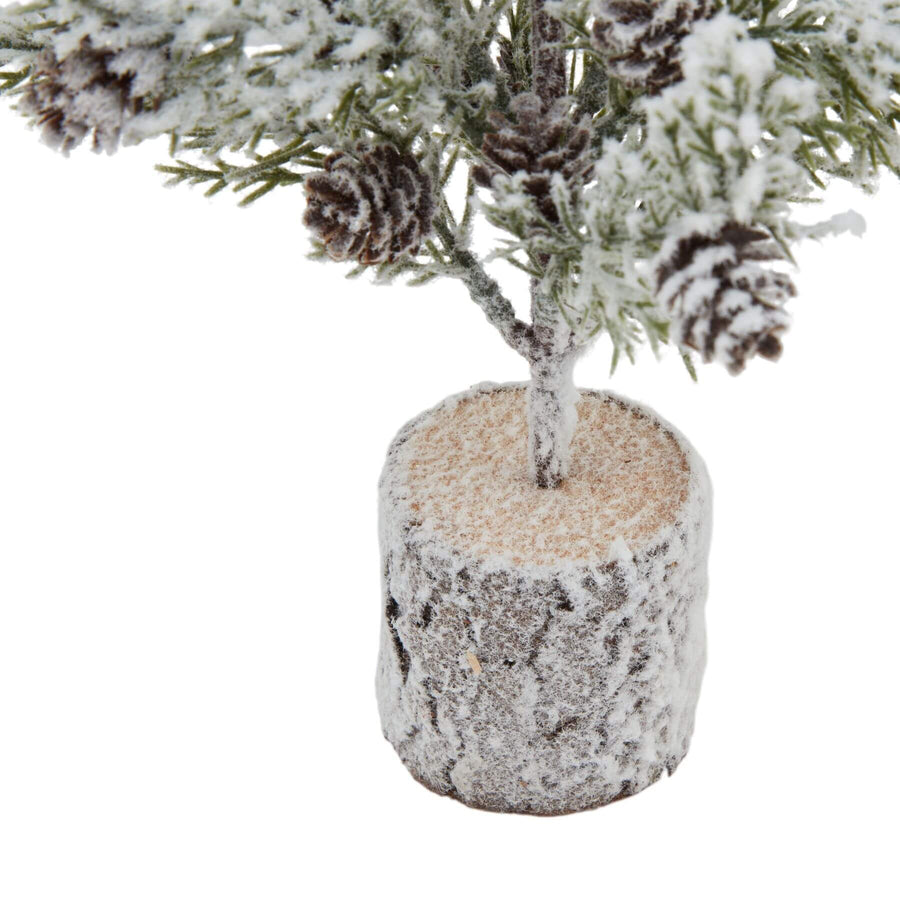 Miniature snow-dusted fir tree on rustic wood base with lifelike pinecones, perfect for winter decor by Sostter at brixbailey.com