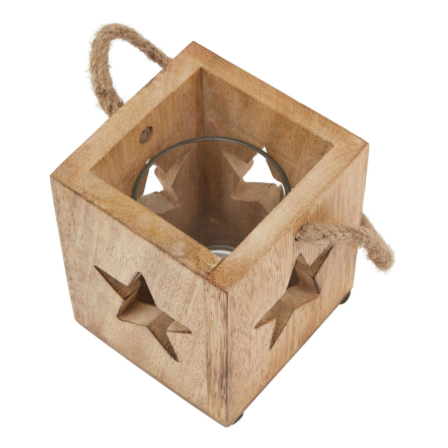 Handcrafted wooden star tealight holder with warm brown finish, casting celestial shadows when lit. by Hill Interiors at brixbailey.com