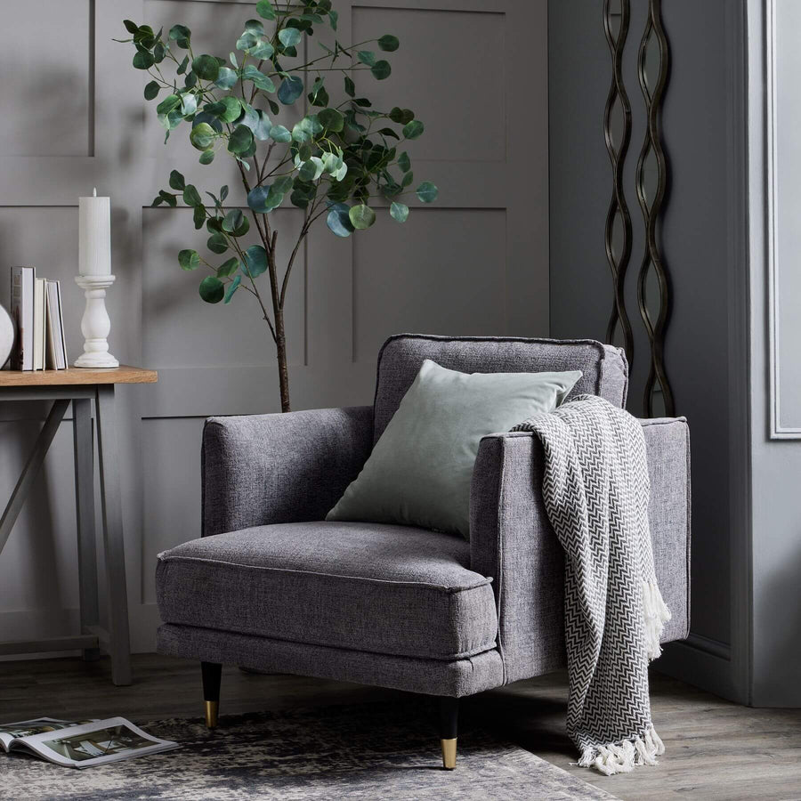 Grey fabric armchair with plush cushioning, curved arms, and neutral tone for modern or traditional interiors. by Sostter at brixbailey.com