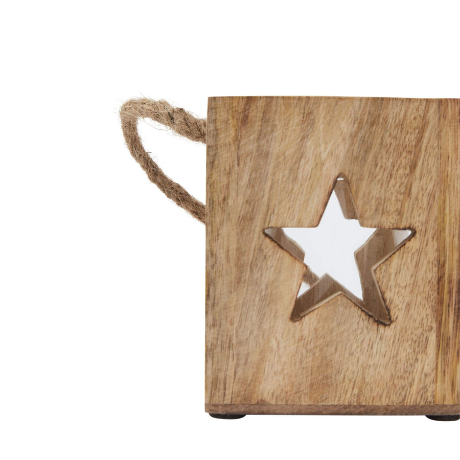 Handcrafted wooden star tealight holder with warm brown finish, casting celestial shadows when lit. by Hill Interiors at brixbailey.com