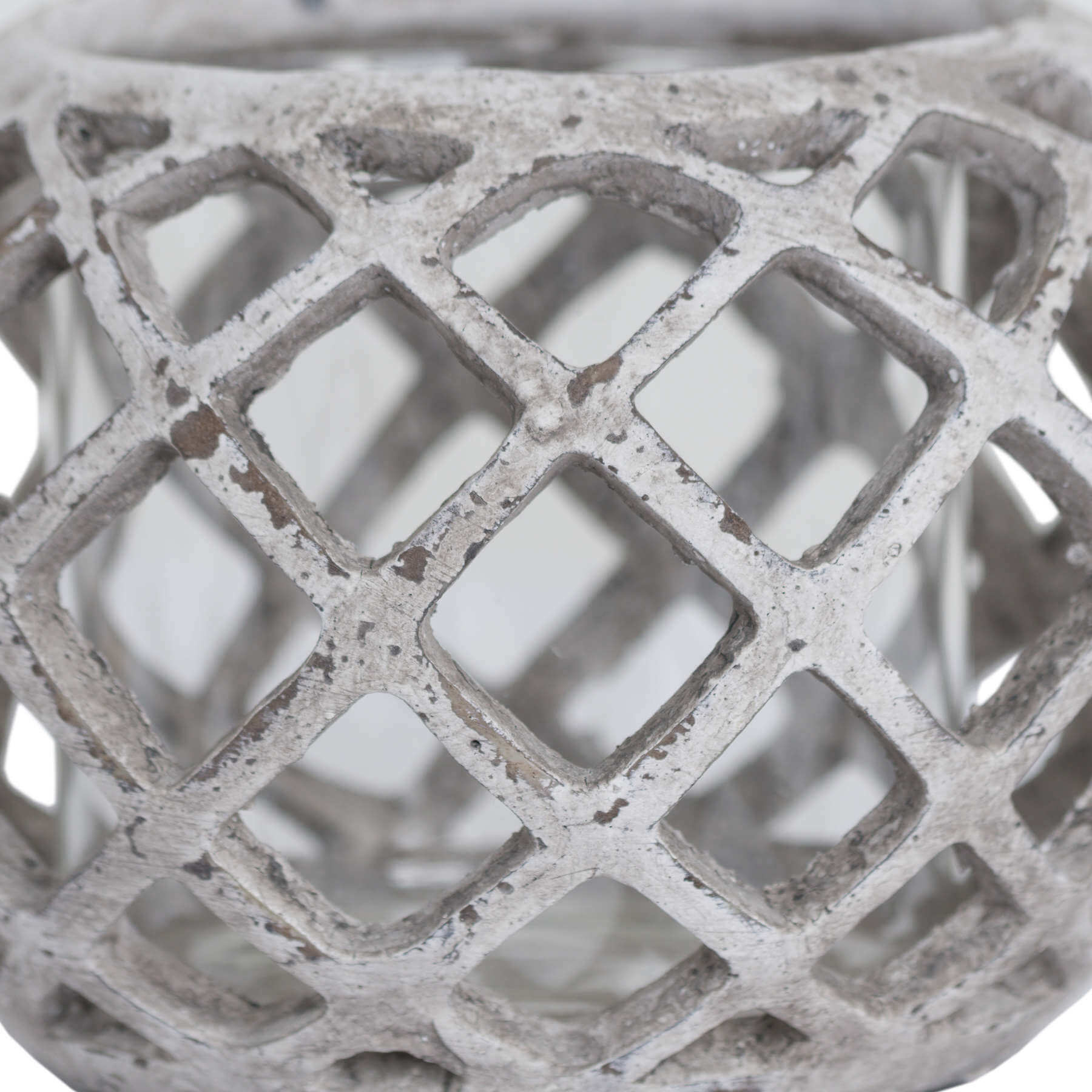 Handcrafted ceramic hurricane lantern with geometric lattice design, casting mesmerizing light patterns in neutral stone finish. by Sostter at brixbailey.com