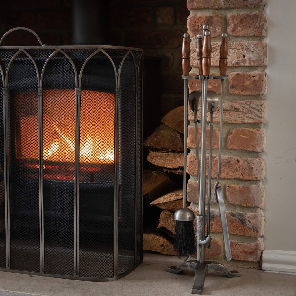 Handcrafted antique pewter fireplace set with wood handles, earthy brown tones, and intricate metalwork. by Sostter at brixbailey.com