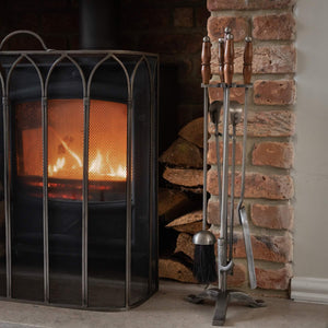 Handcrafted antique pewter fireplace set with wood handles, earthy brown tones, and intricate metalwork. by Sostter at brixbailey.com