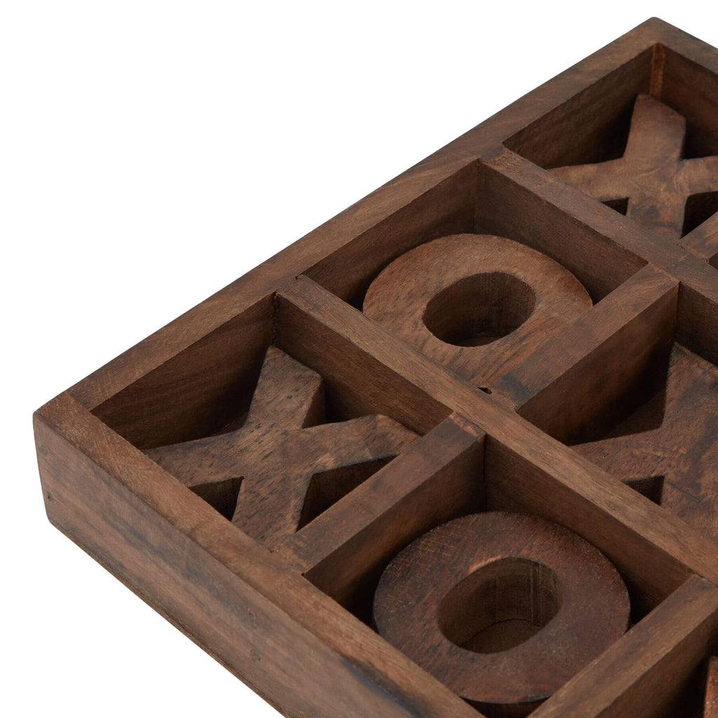 a playful mid-game shot of the wooden noughts and crosses set on a sunlit table