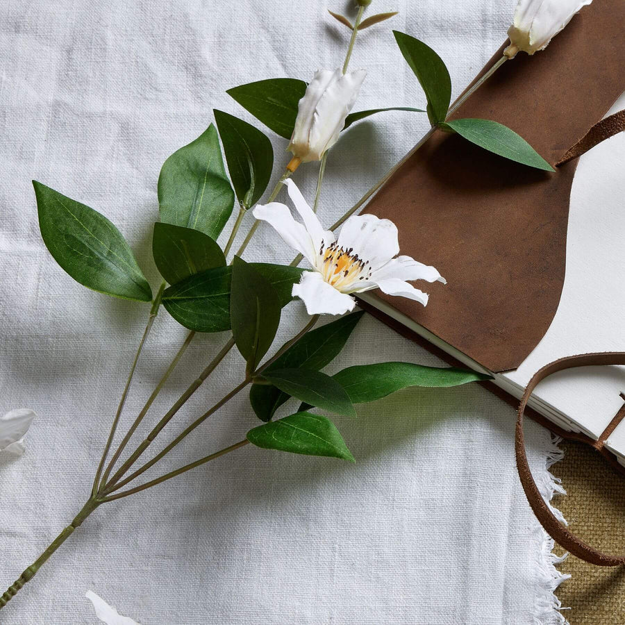 Lifelike white artificial clematis stems with green foliage, 77cm tall, for realistic floral arrangements by Sostter at brixbailey.com