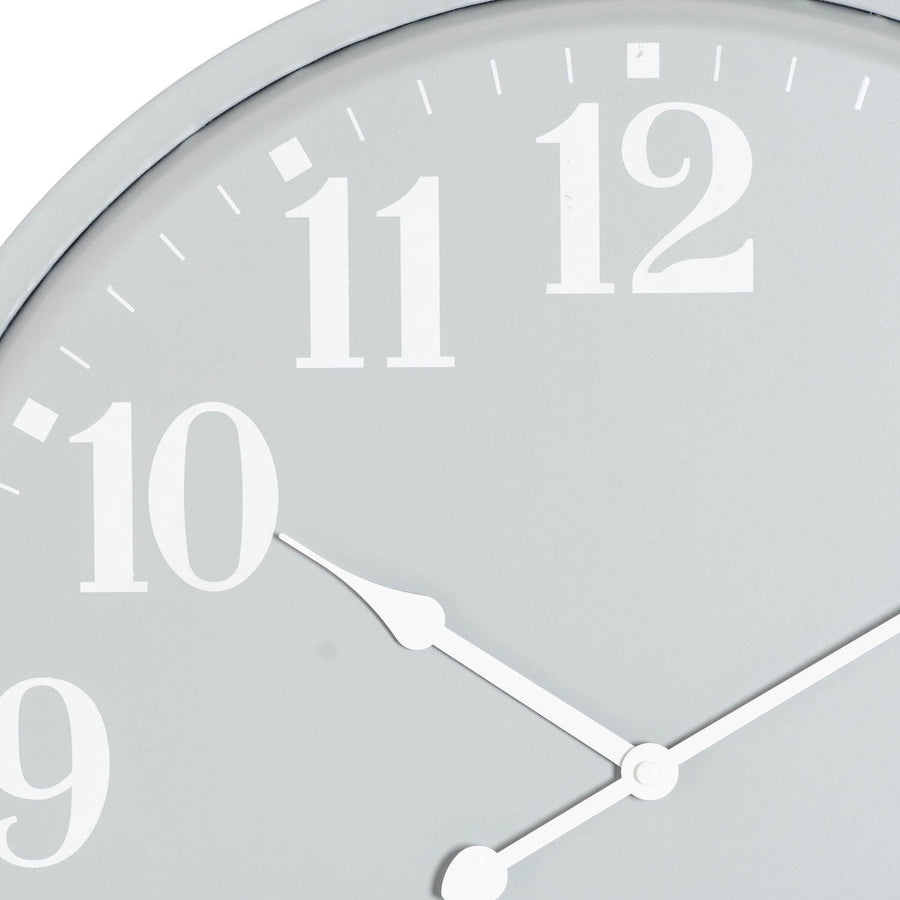 Modern grey metal wall clock with geometric design, casting dynamic shadows, perfect for industrial or Scandinavian decor by Sostter at brixbailey.com