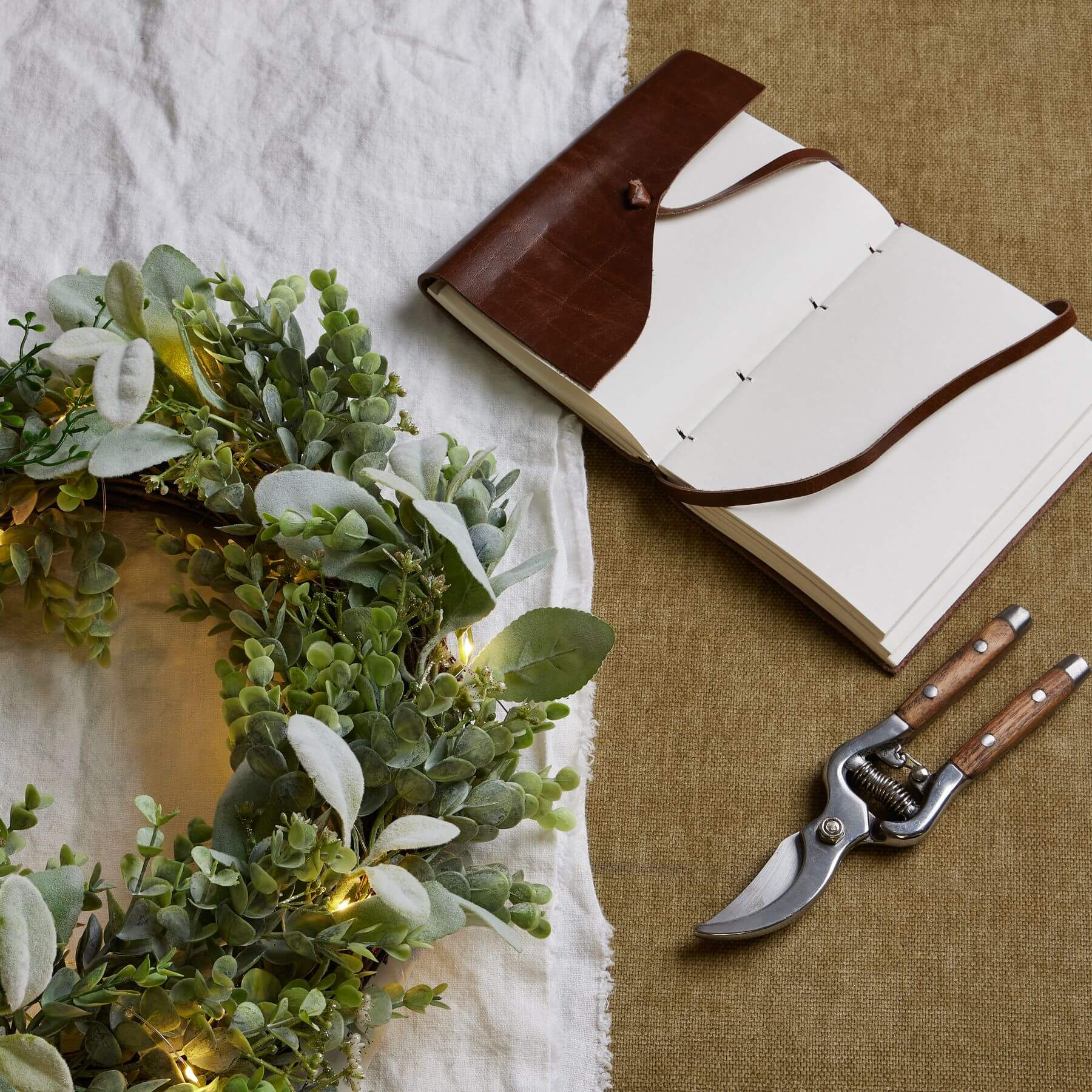 Handcrafted LED winter wreath with eucalyptus and lambâ€™s ear foliage, glowing natural green with silvery accents. by Sostter at brixbailey.com