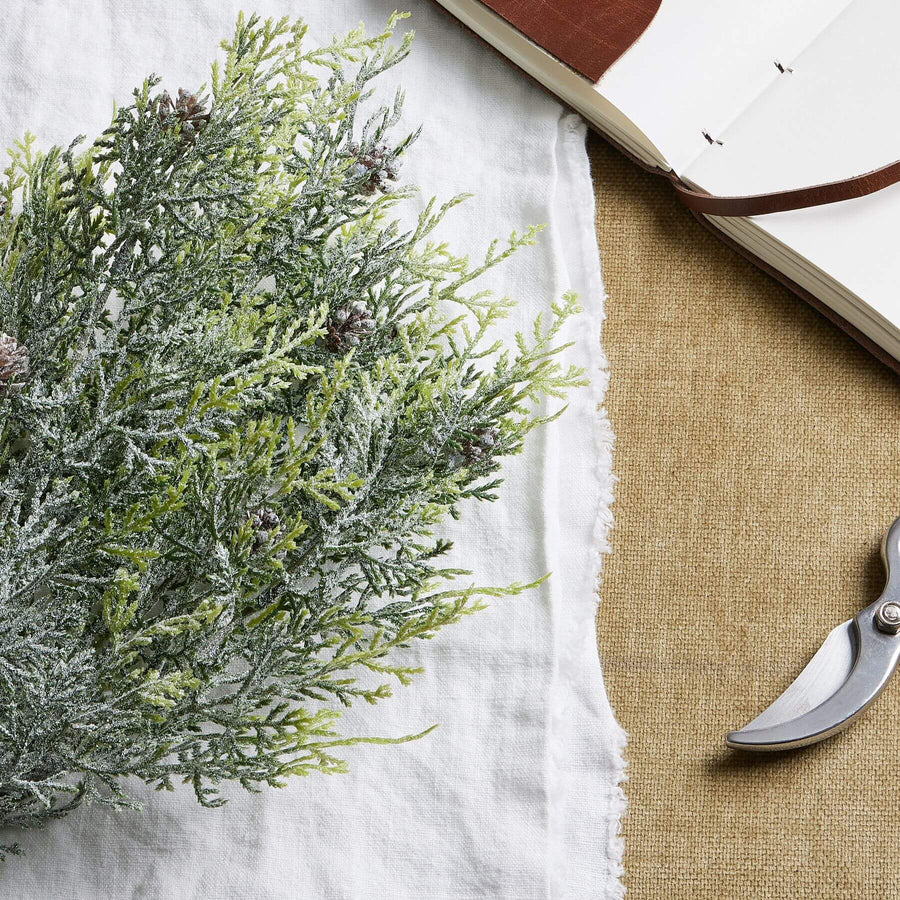 Lifelike frosted pine spray with delicate winter frost accents and pinecones for seasonal home dÃ©cor by Sostter at brixbailey.com