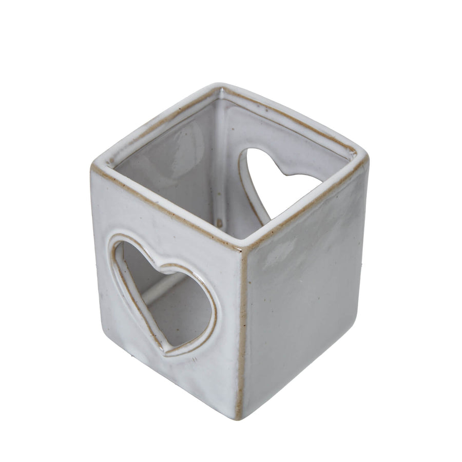 White ceramic tealight holder with heart cutout, Scandinavian minimalist design for ambient lighting by Hill Interiors at brixbailey.com