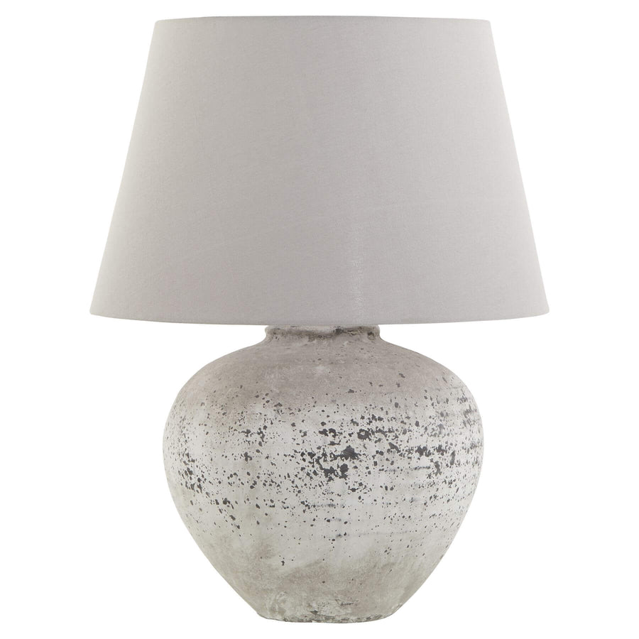 Handcrafted stone-effect ceramic lamp with light grey fabric shade, organic texture, and warm ambient glow by Sostter at brixbailey.com