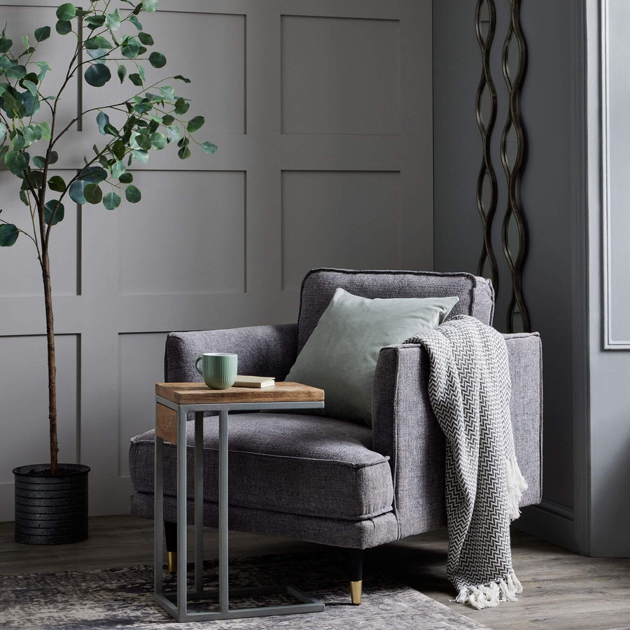Grey fabric armchair with plush cushioning, curved arms, and neutral design for modern or traditional interiors. by Sostter at brixbailey.com
