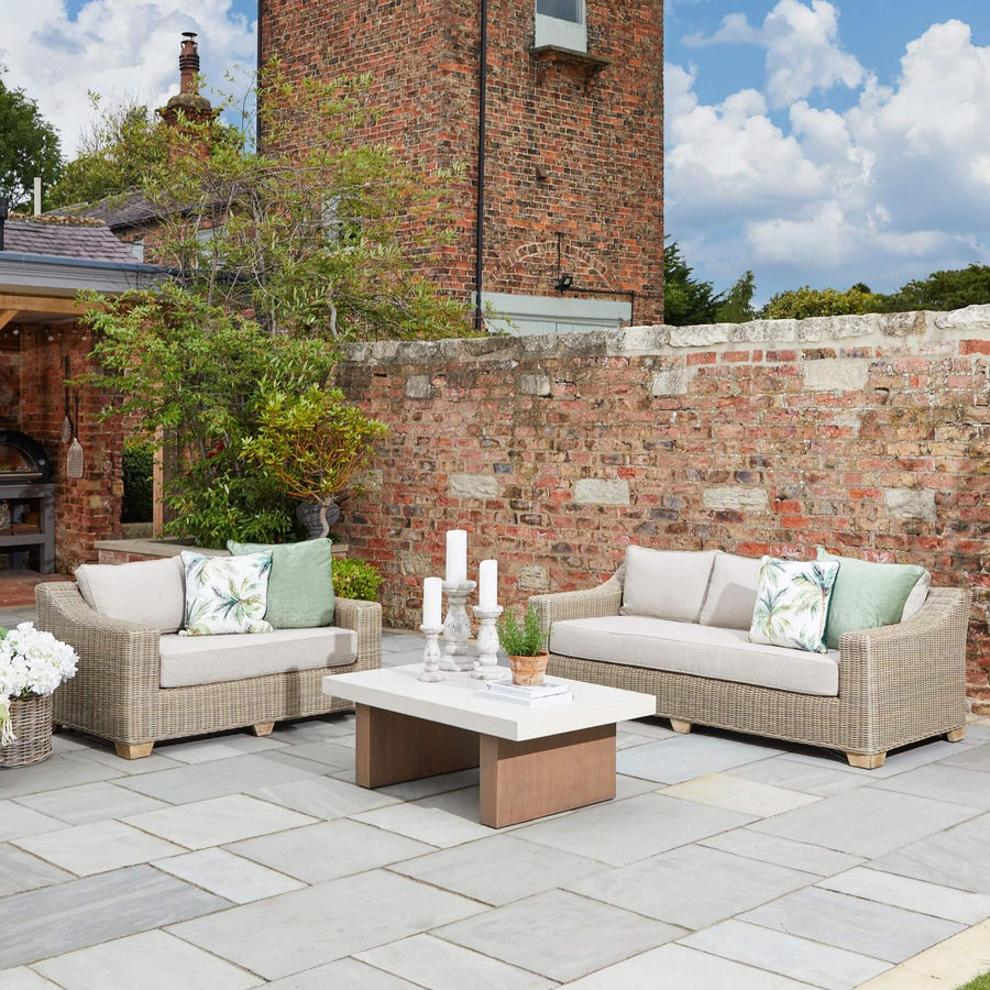 Beige outdoor two-seater sofa with HDPE wicker weave, aluminum frame, and acacia wood feet for patio or garden. by Sostter at brixbailey.com