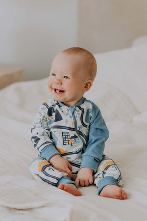 confident baby in a bold city life sleepsuit with two-way zipper and ribbed cuffs