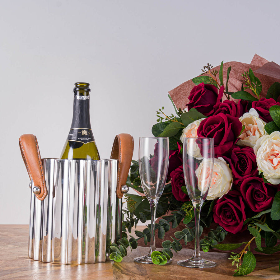 Silver fluted champagne cooler with stainless steel body and leather handles, reflecting light elegantly. by Sostter at brixbailey.com