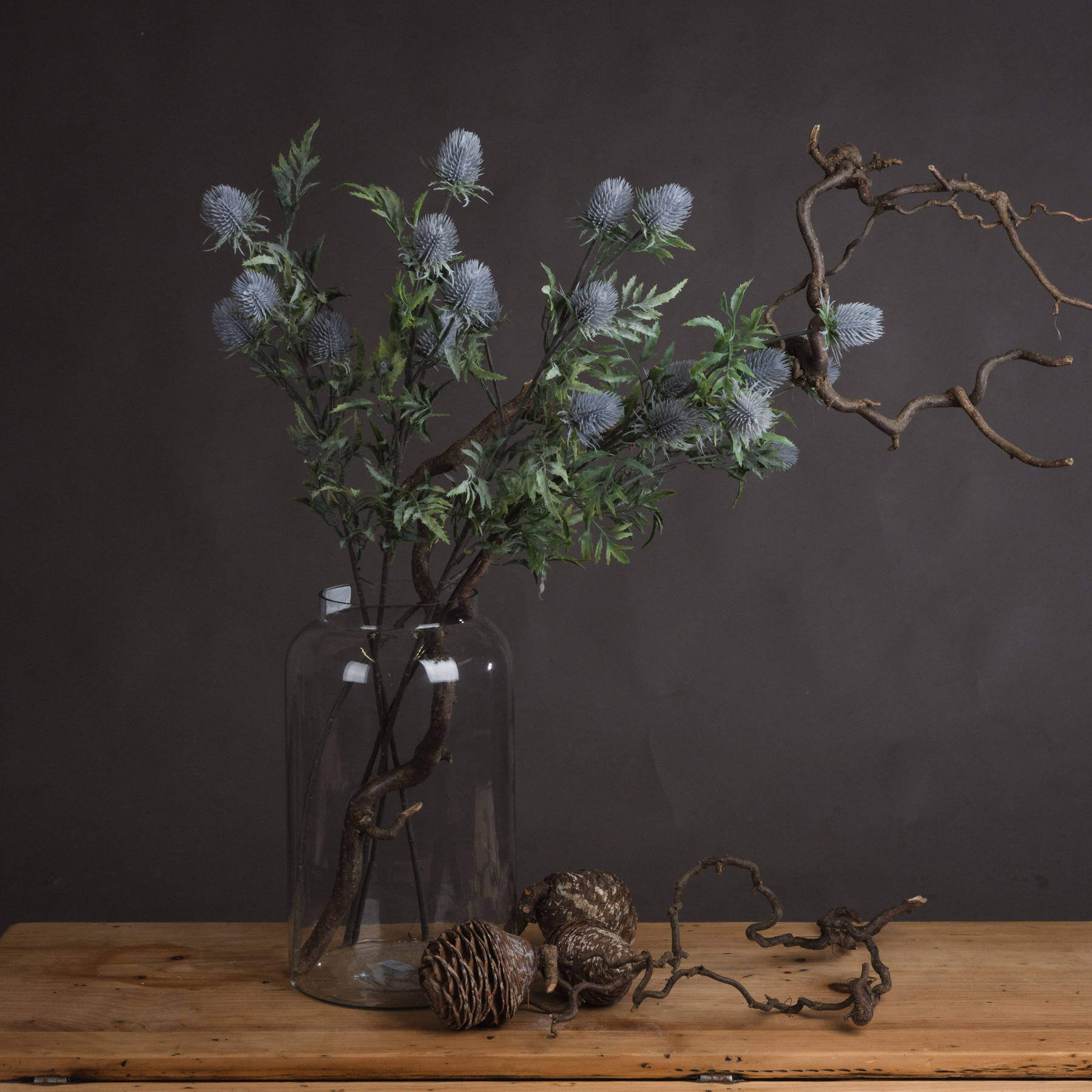 Artificial blue thistle stem with powder-blue petals and lifelike cone, perfect for rustic or coastal floral arrangements by Sostter at brixbailey.com