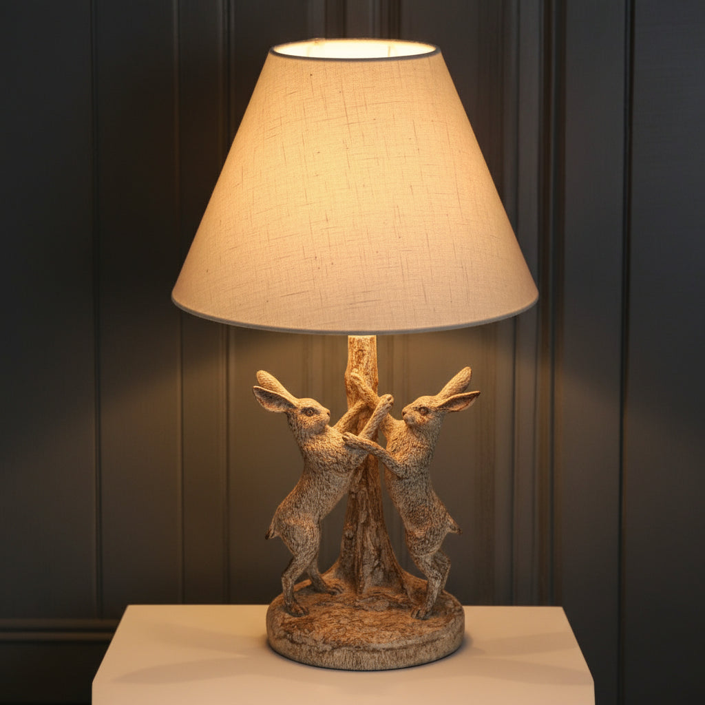 Stonewashed grey-brown Marching Hares table lamp with sculpted resin hares and natural linen shade by sostter at brixbailey.com