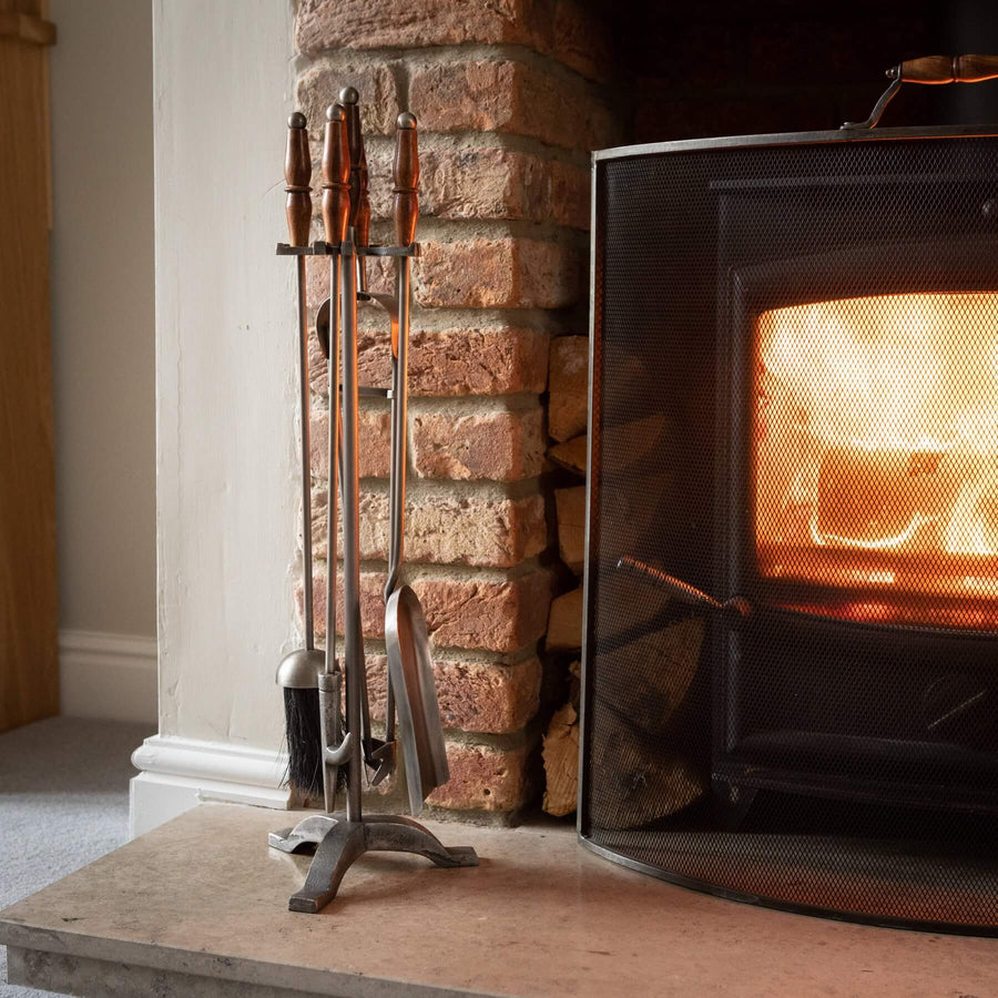 Handcrafted antique pewter fireplace set with wooden handles, earthy brown tones, and intricate metalwork. by Sostter at brixbailey.com