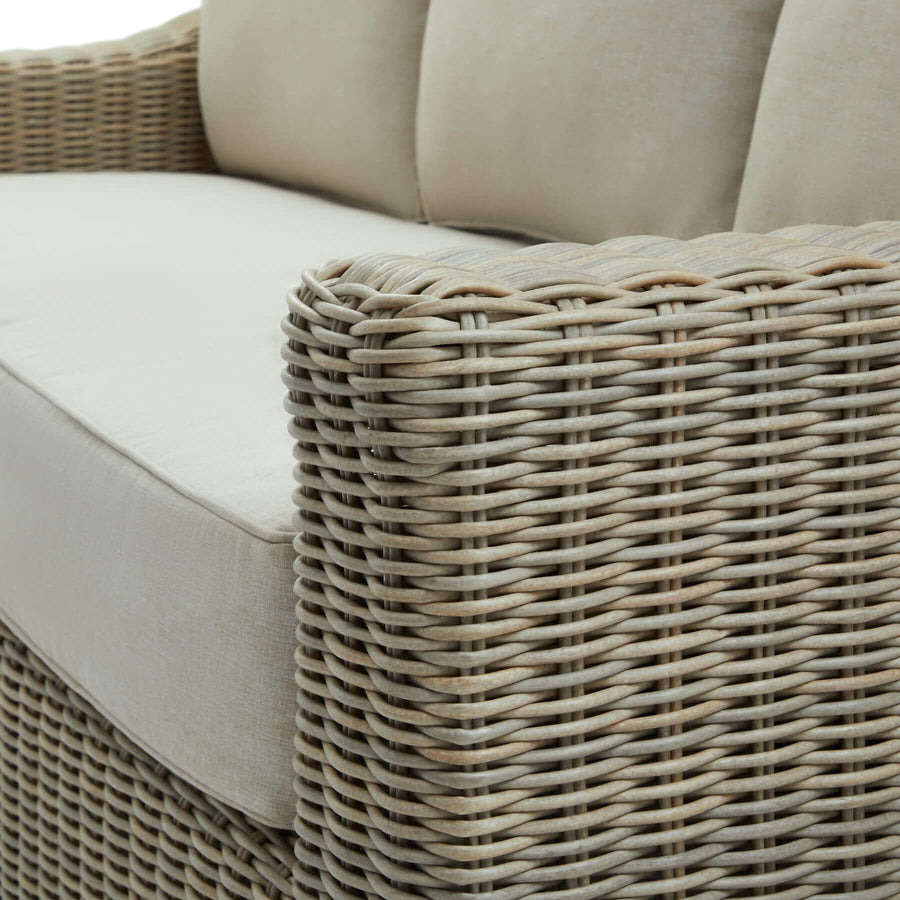 Handcrafted beige wicker sofa with HDPE weave, aluminum frame, and acacia wood feet for outdoor luxury seating. by Sostter at brixbailey.com