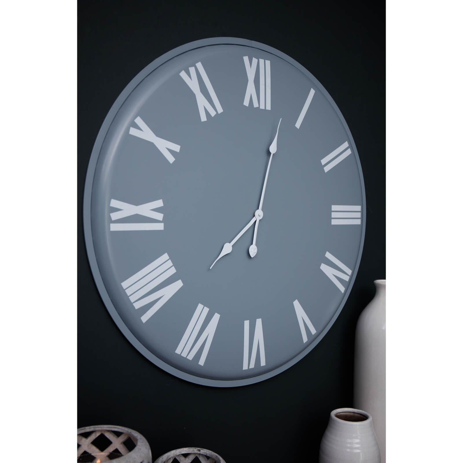 Large grey wall clock with white roman numerals, minimalist metal design, 49cm diameter, modern statement piece by Sostter at brixbailey.com