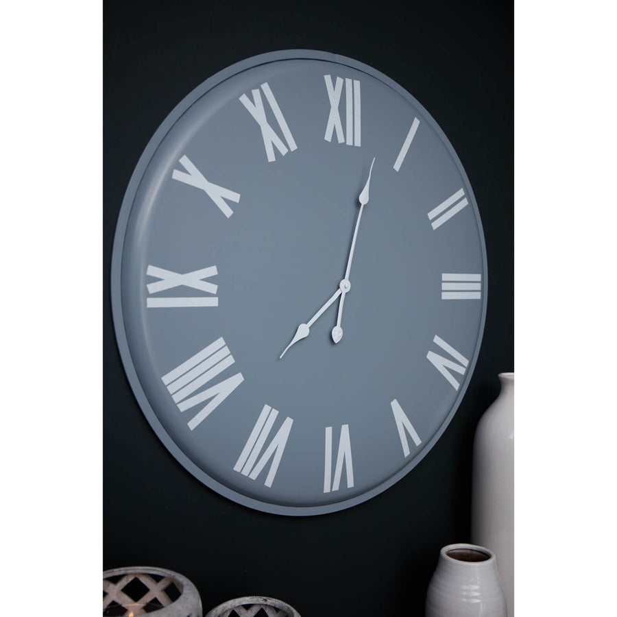 Large grey wall clock with white roman numerals, minimalist metal design, 49cm diameter, modern statement piece by Sostter at brixbailey.com