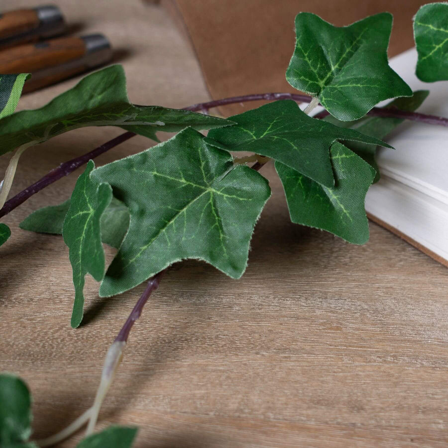 Lush artificial ivy garland with realistic silk leaves in natural green hues, perfect for mantels or wedding decor by Sostter at brixbailey.com