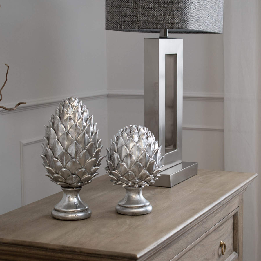 Handcrafted silver ceramic pinecone finial with intricate metallic detailing for elegant home decor. by Sostter at brixbailey.com