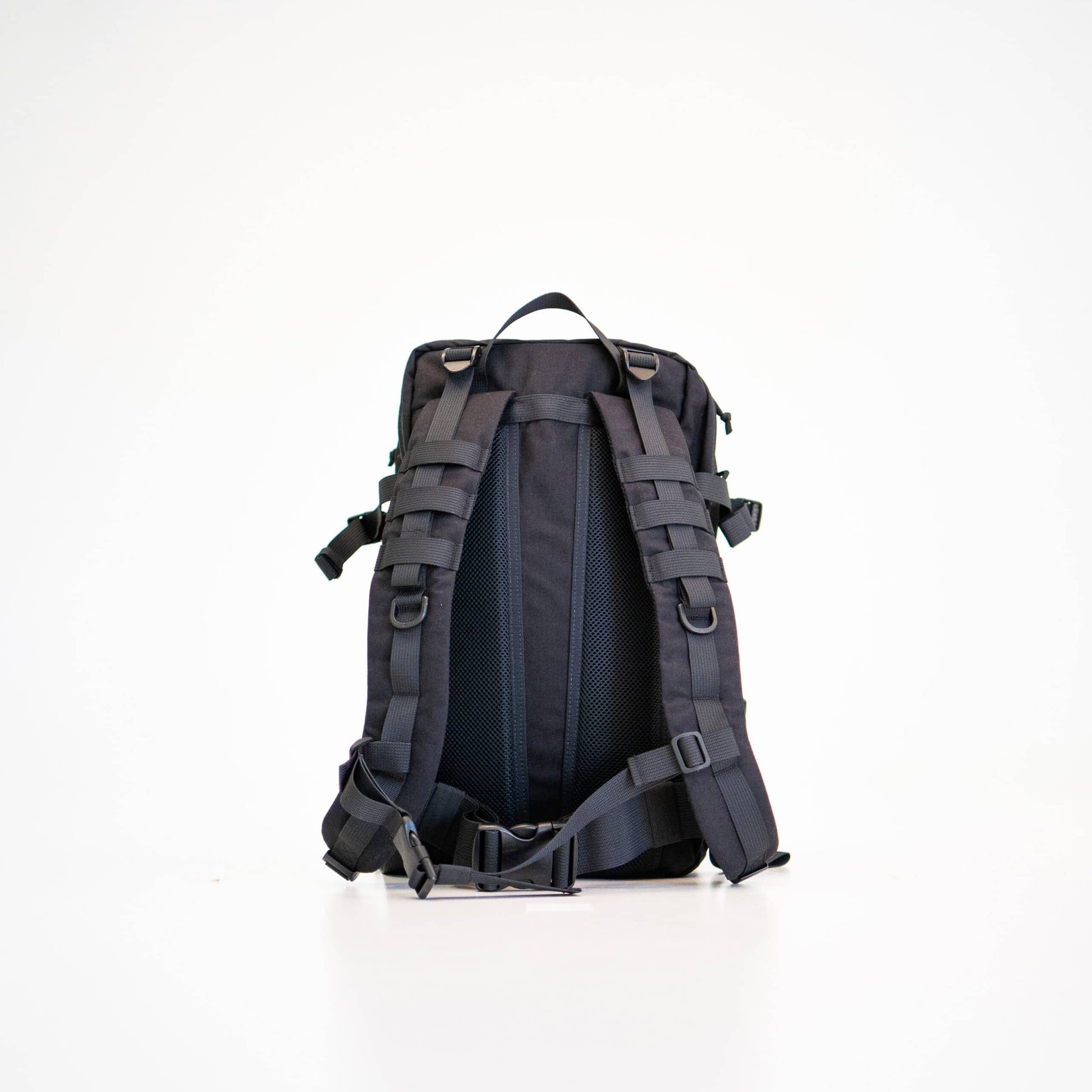 a soft-focused side view of the durable black backpack with its comfortable padded straps visible
