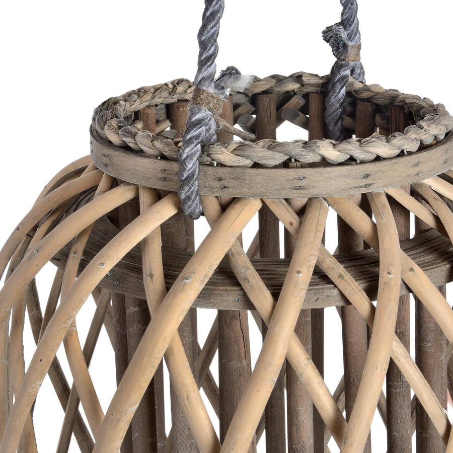 Handwoven rattan lantern in rich brown, casting warm light patterns for indoor or outdoor ambiance. by Sostter at brixbailey.com