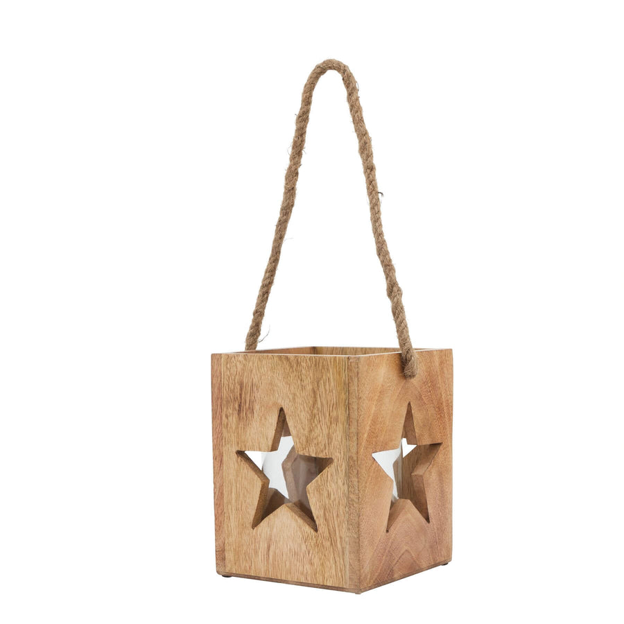 Handcrafted wooden star tealight holder with intricate celestial design, casting warm boho shadows on natural wood. by Sostter at brixbailey.com