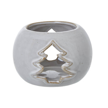 White ceramic tealight holder with tree cut-out pattern casting dancing shadows, creating warm ambiance for home decor. by Sostter at brixbailey.com
