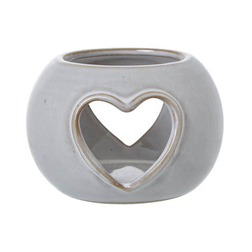 White ceramic tealight holder with heart-shaped cutouts, creating warm ambient light patterns for cozy decor by Hill Interiors at brixbailey.com
