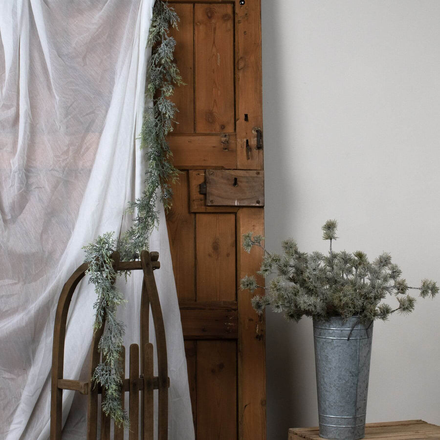 Frost-dusted pine garland with lifelike needles and pinecones, white with sparkling winter frost accents by Sostter at brixbailey.com